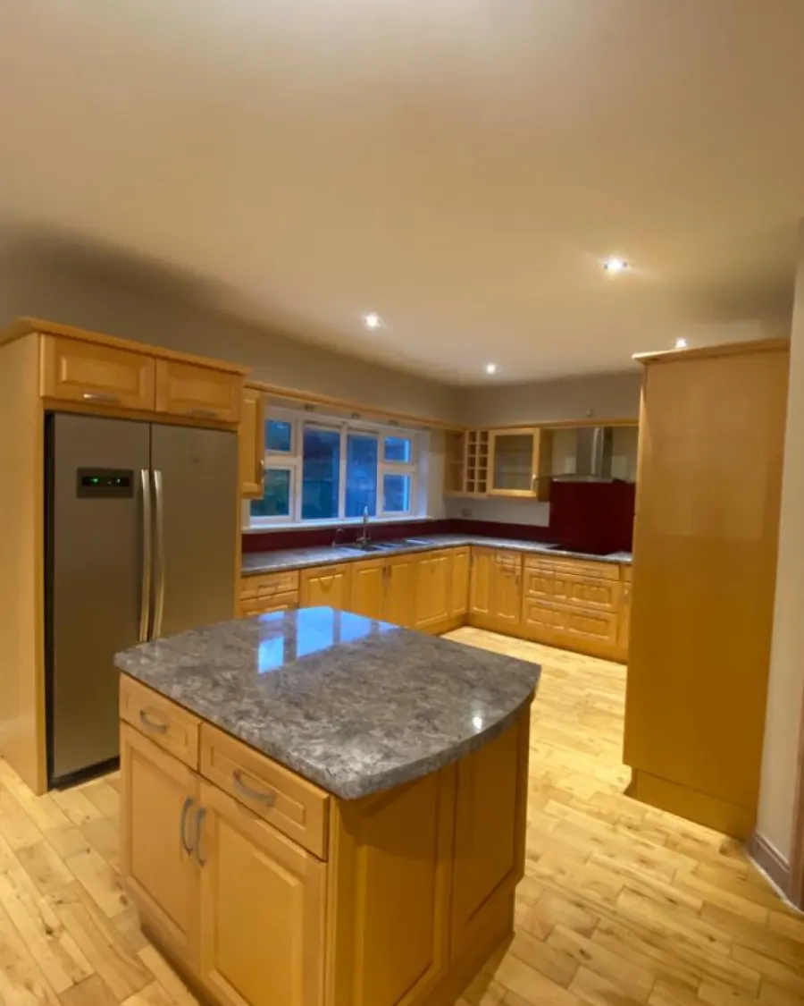 Oak kitchen with a granite-topped island before respraying