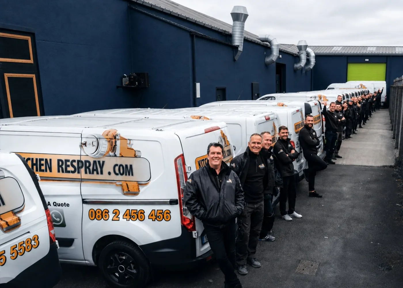 The Kitchen Respray team lined up beside our branded vans outside the workshop