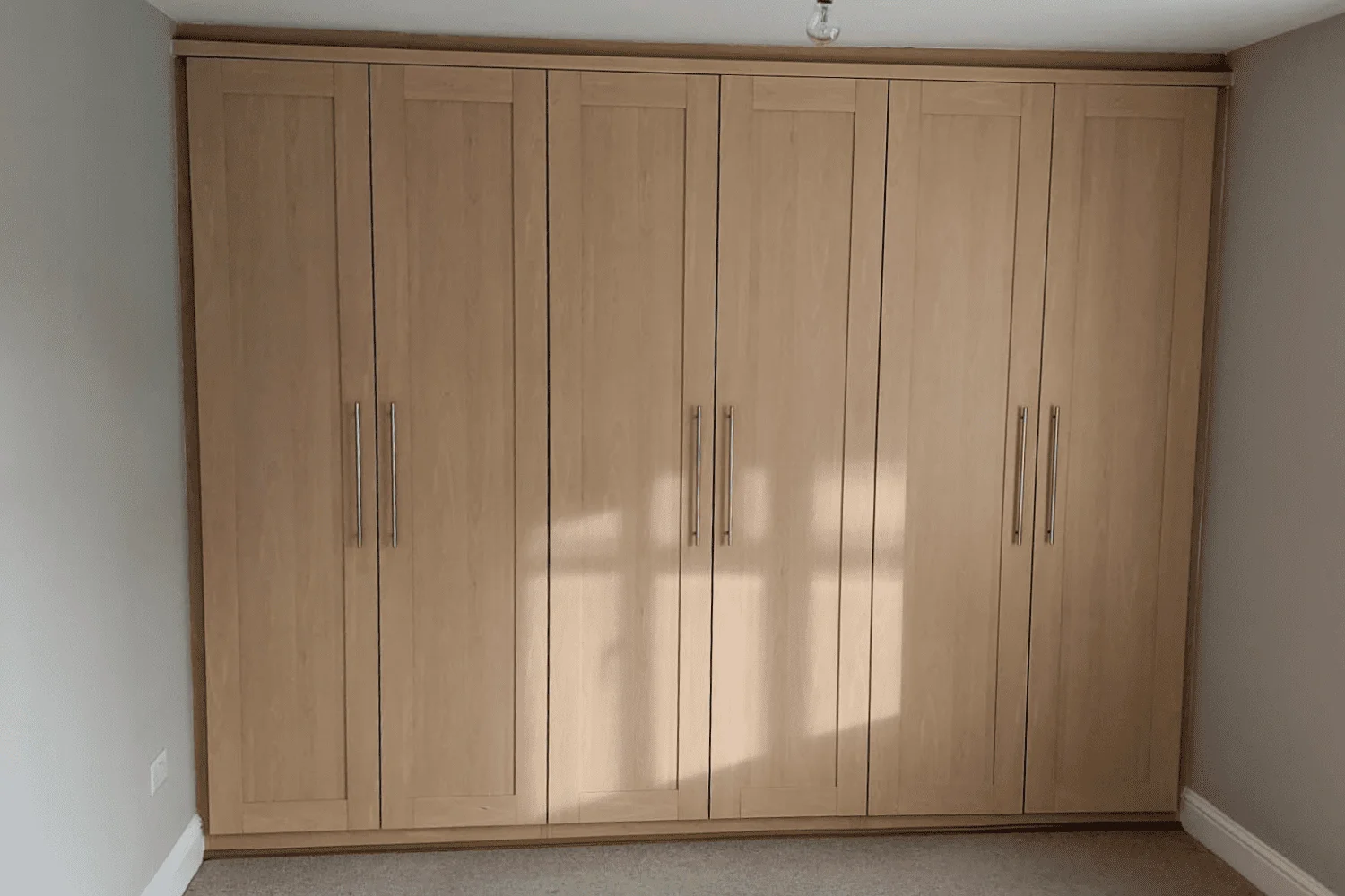 Fitted wardrobes with a light oak finish before respraying