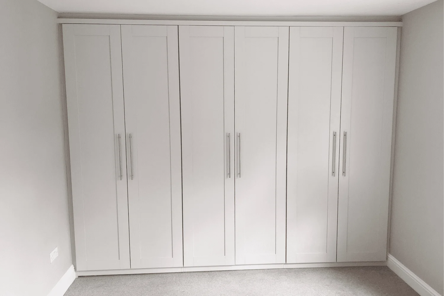 The same fitted wardrobes resprayed in a soft white finish